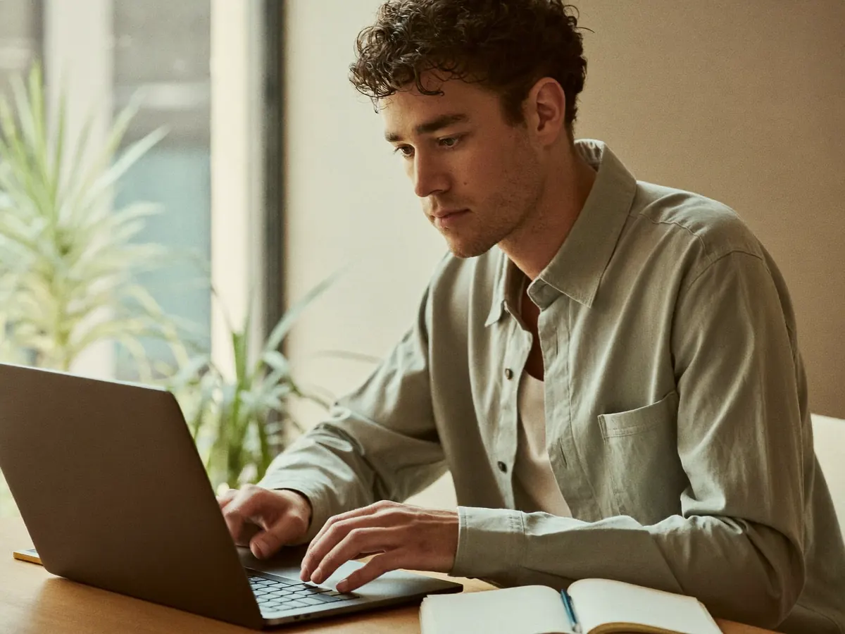 Employee writing a follow-up email at a window desk